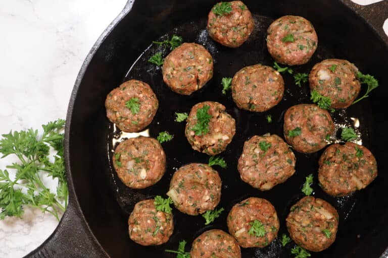 Lamb kofta in a cast iron skillet before cooking