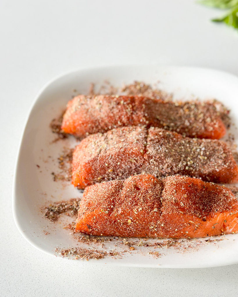 three fillets of salmon seasoned with spices