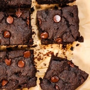 4 vegan gluten free brownies on parchment papeer