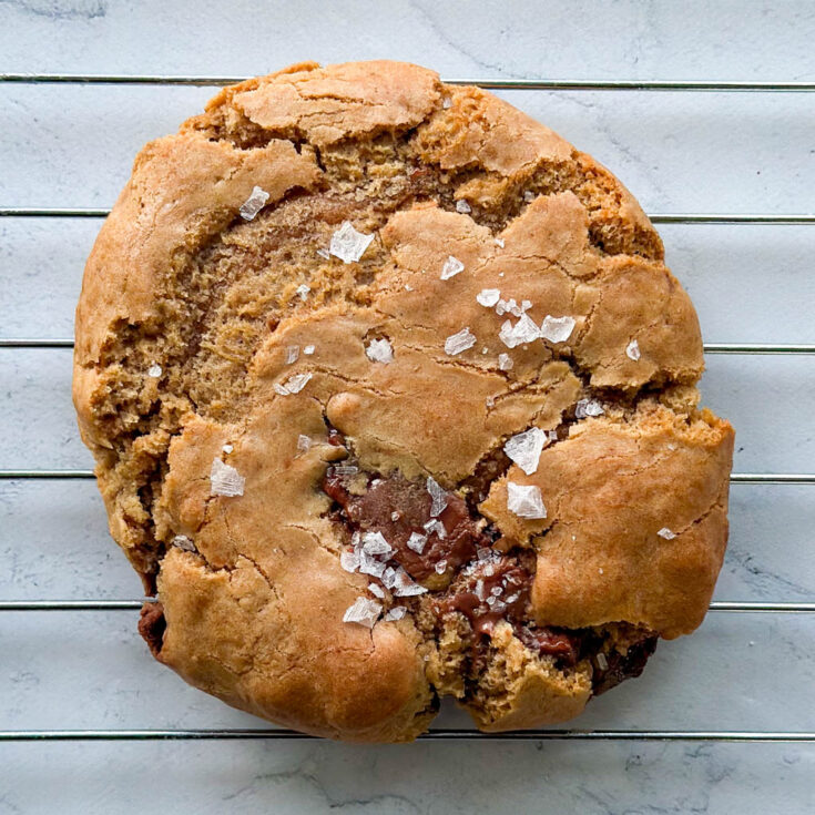 close up view of a vegan gluten free chocolate chip cookies topped with flaky salt