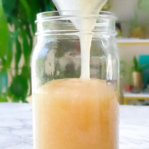 sea moss being poured into a large mason jar