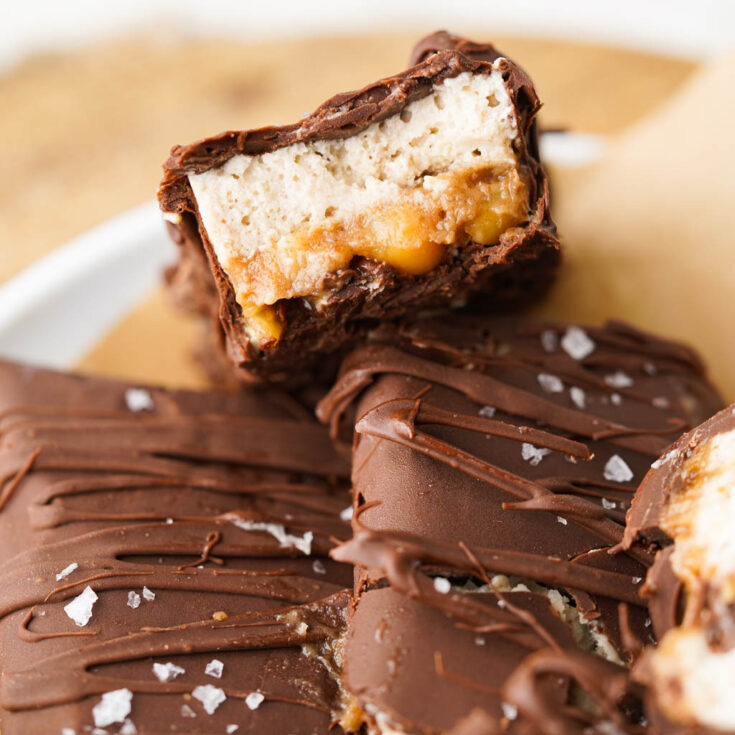 inside of a ice cream snickers bar shown and it is sitting on two ice cream snickers bars