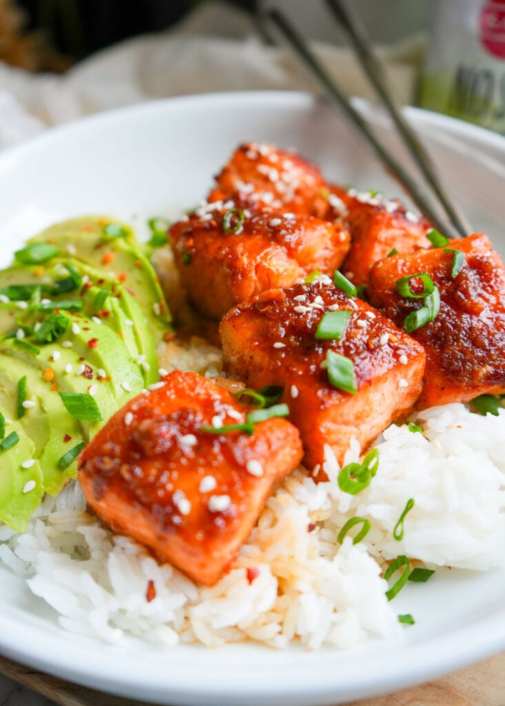 ginger maple salmon bites in a bowl with white rice and avocado