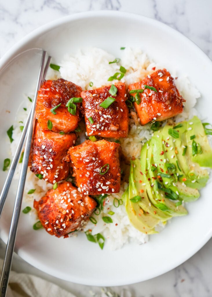 ginger maple salmon bites in a bowl with white rice and avocado