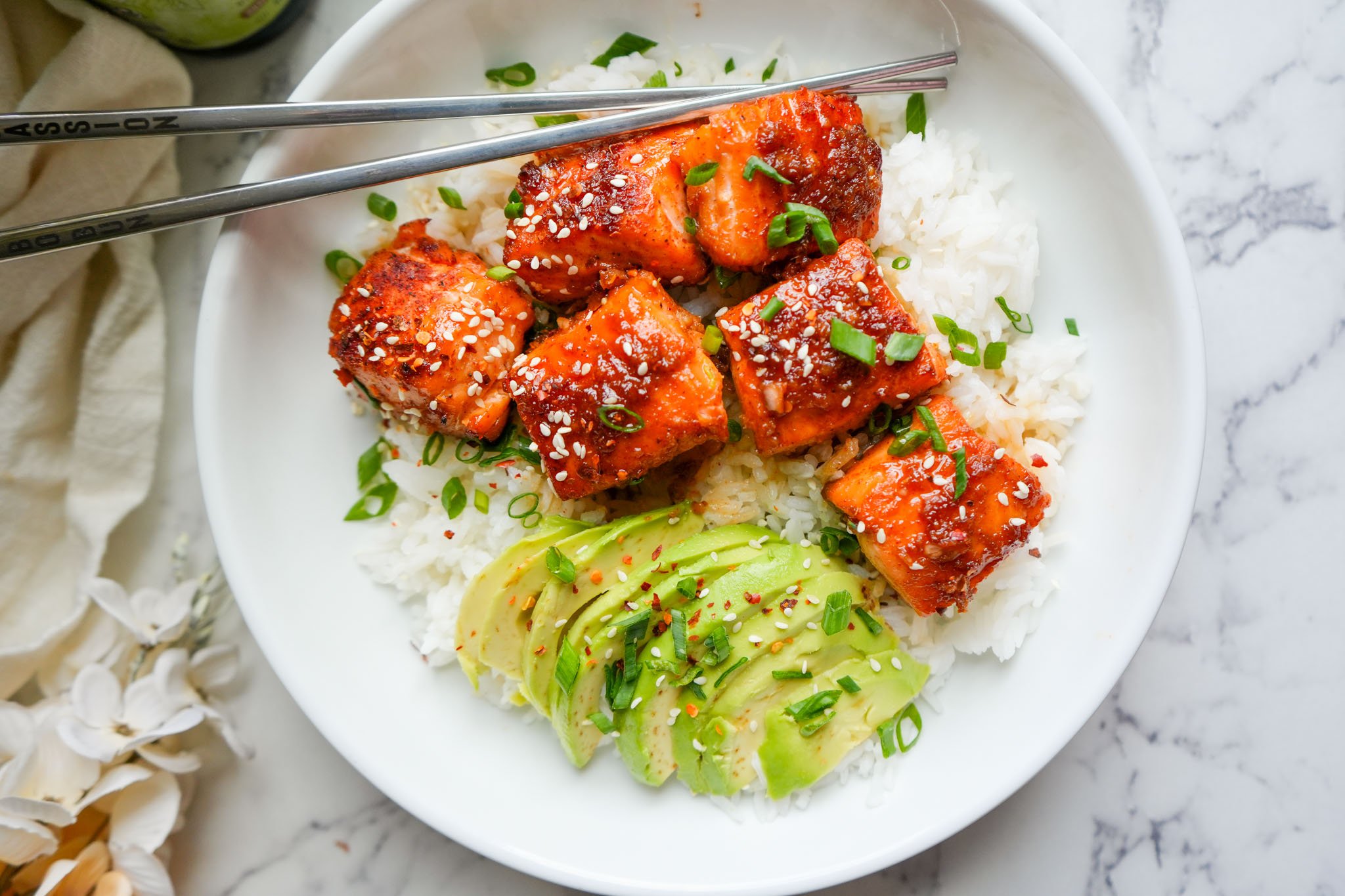 ginger maple salmon bites in a bowl with white rice and avocado