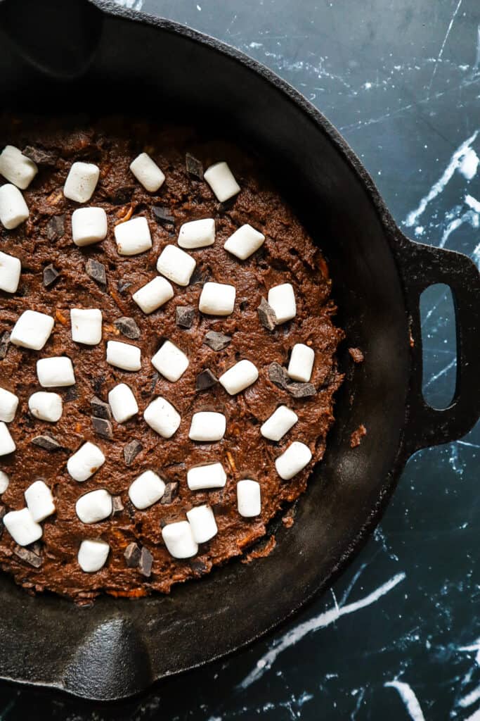 brownies in a skillet uncooked with marshmallows and chocolate chips