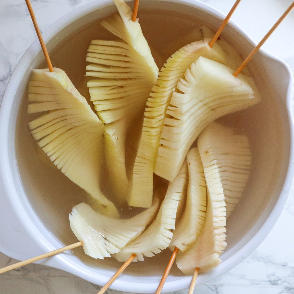 accordion potatoes in a bowl of water