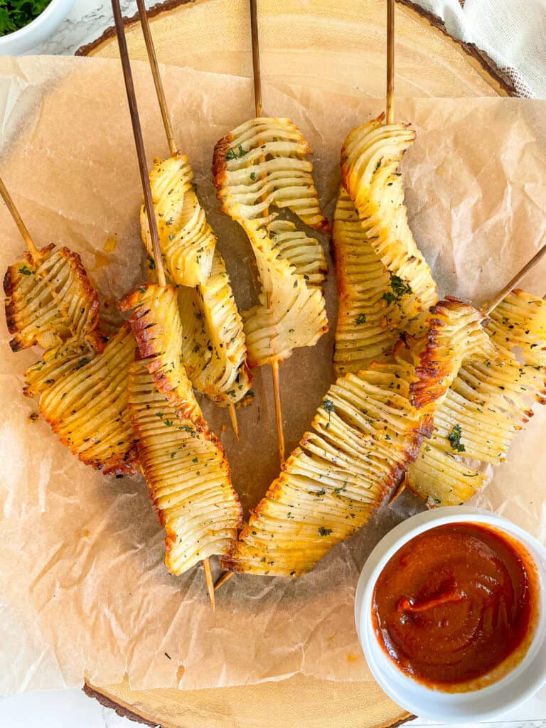 overhead image of accordion potato skewers with sriracha curry ketchup 