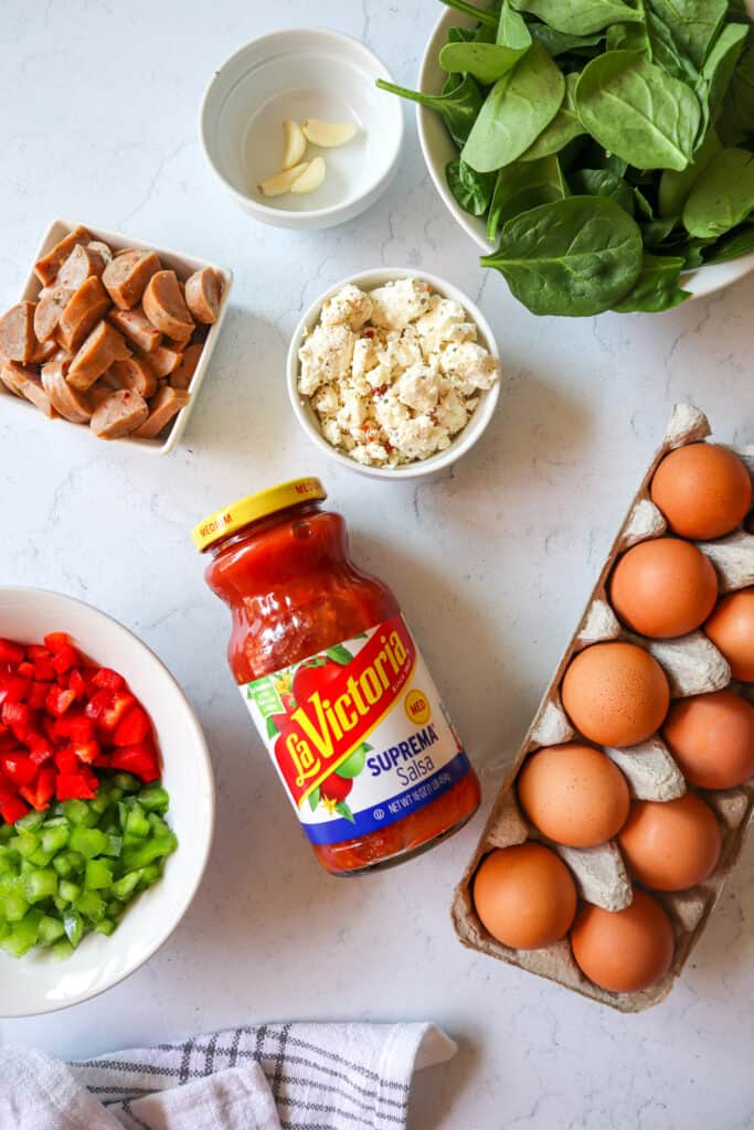 ingredients needed to make egg muffins: spinach, cheese, fresh garlic, eggs, LaVictoria Salsa, chopped peppers, sliced sausage