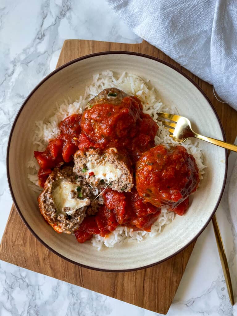 Air Fryer Cheese Stuffed Meatballs with Marinara Sauce served over rice