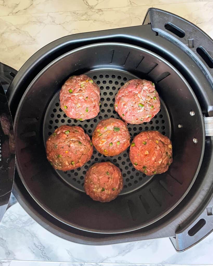 Raw Meatballs arranged in the air fryer for cooking