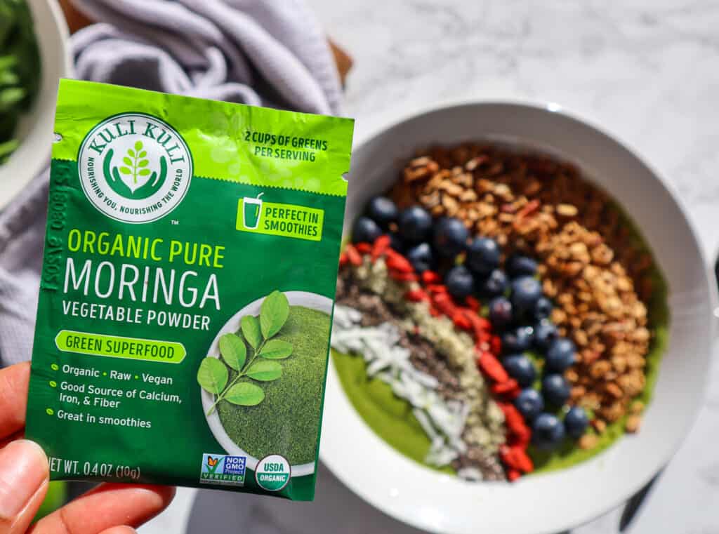 Moringa Powder Packet with smoothie bowl in background