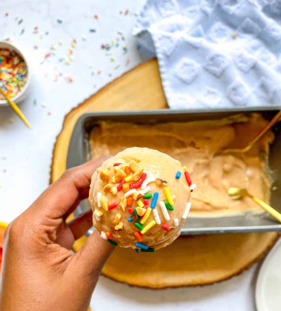 Healthy Papaya Ice Cream with sprinkles in a gluten free cone