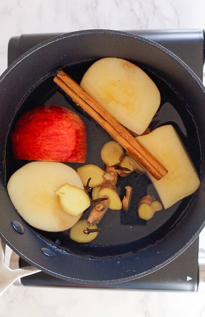 ingredients to make cold fighting tea: apple, ginger, cinnamon, cloves