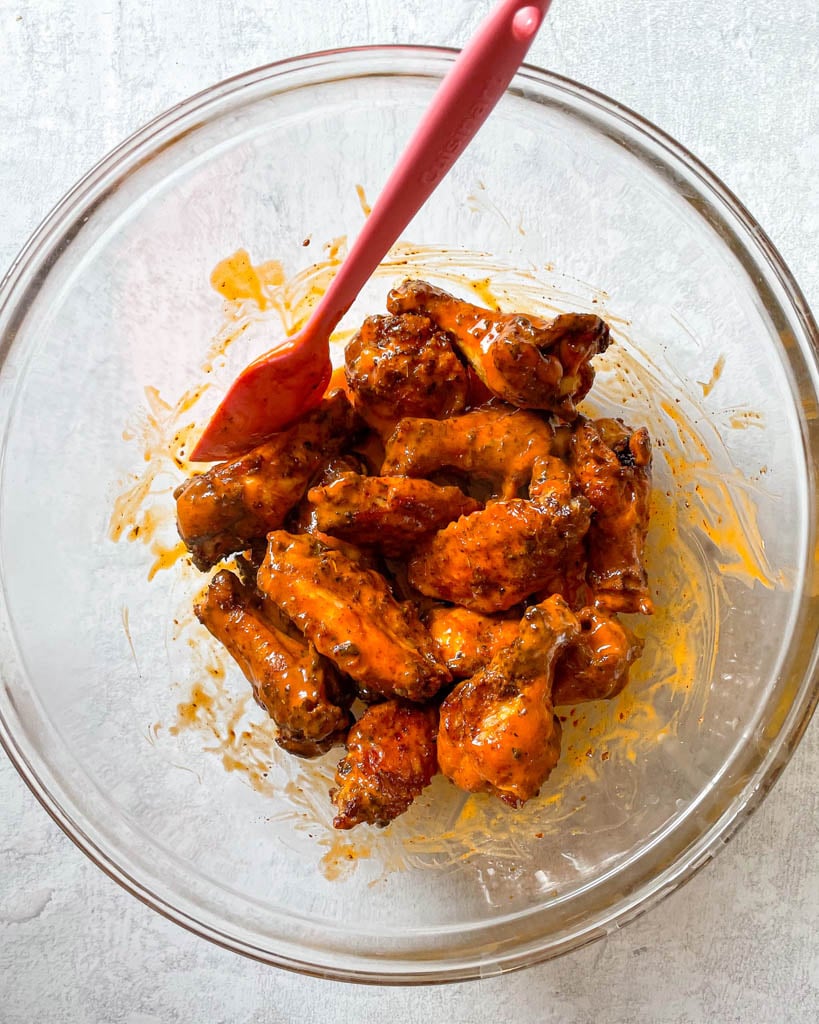 chicken wings coated in buffalo sauce in a large bowl