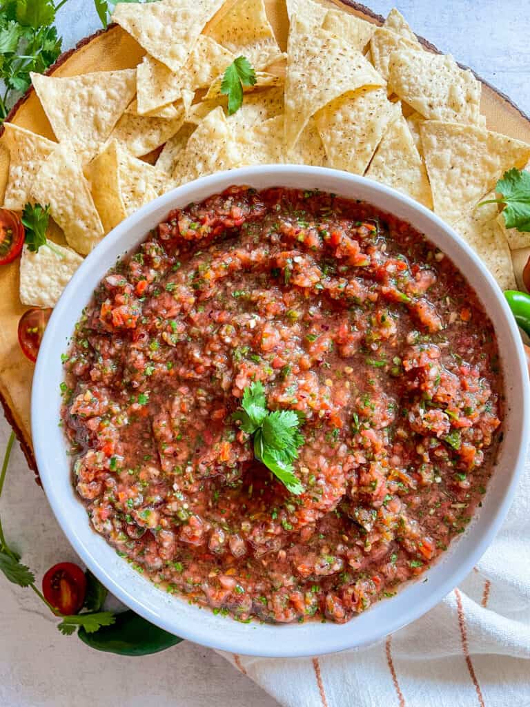 Homemade fresh salsa with chips served on a wood platter