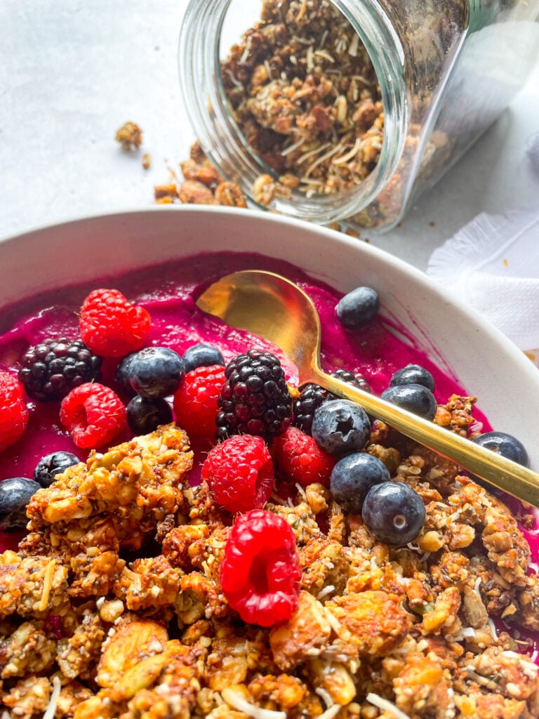 dragonfruit smoothie bowl topped with fresh berries, and grainless granola