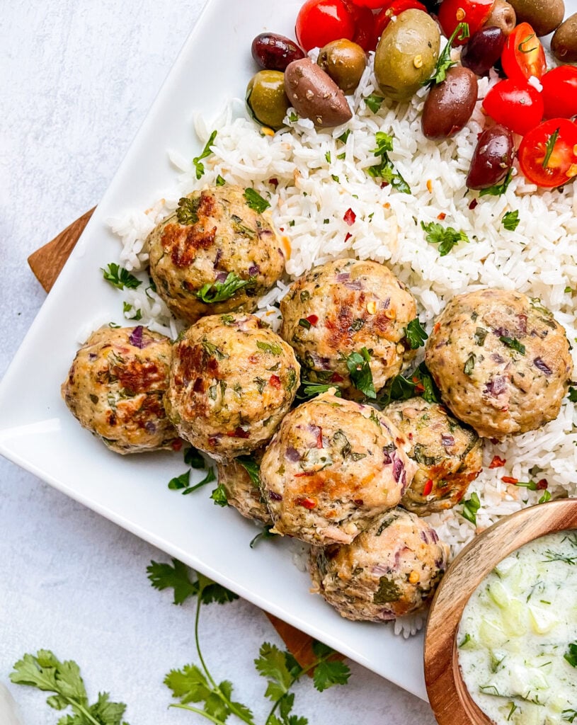 mediterranean meatballs plated with rice tomatoes and olives
