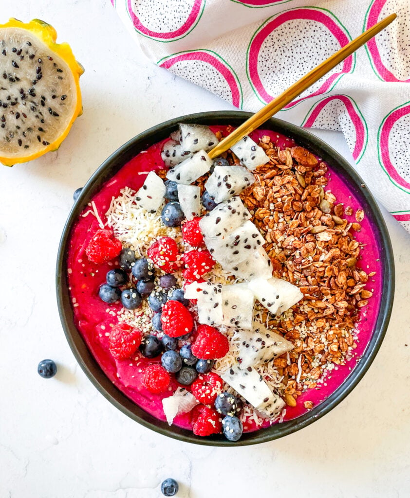dragonfruit smoothie bowl topped with fresh berries, hemp seeds and sliced dragonfruit