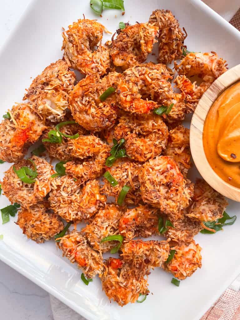 plate of air fryer coconut shrimp with a side of dipping sauce
