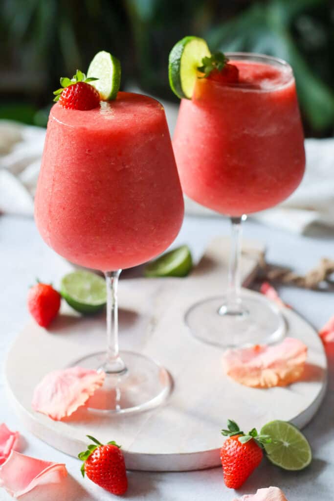 two strawberry watermelon froses in a tall wine glass