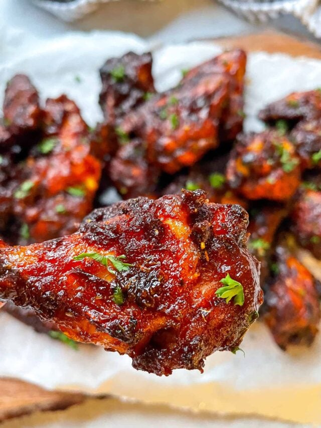 a bbq chicken wing drum with a platter of wings in the background