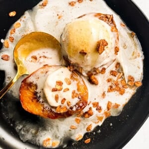 overhead view of air fryer peaches topped with granola, ice cream and cinnamon