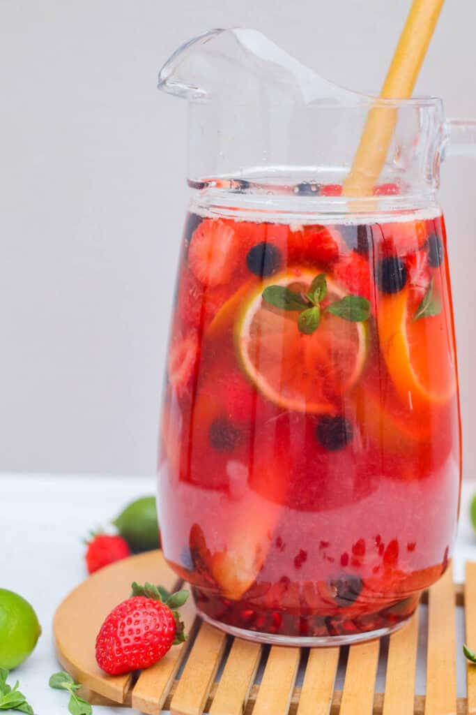 a large pitcher of rose sangria with fresh fruit 