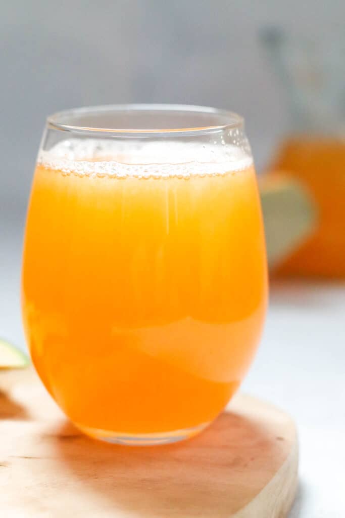 Glass of cantaloupe juice on a wooden board 