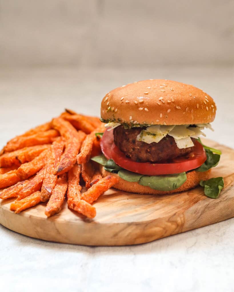 Air Fryer Turkey Burger on a Gluten-Free Bun With Pesto, Fresh Grated Parmesan, Tomato, and Lettuce. Served with Sweet Potato Fries