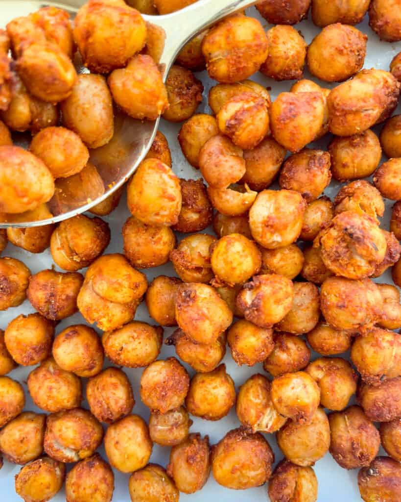 close up of crispy air fried chickpeas with a gold spoon with crispy chickpeas on it