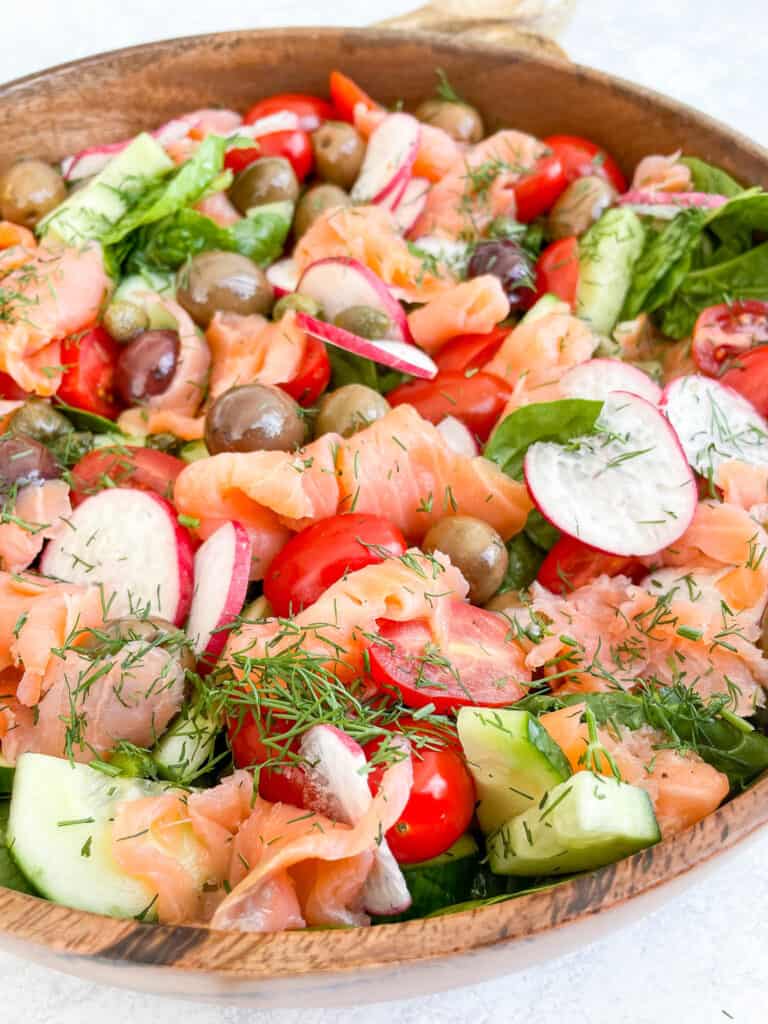 close up angle of smoked salmon salad in a large wooden bowl
