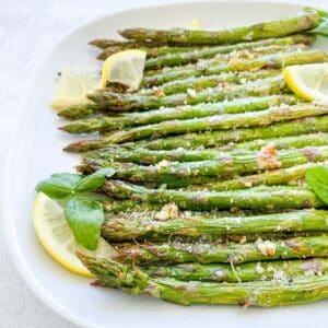 plated asparagus with lemon wedges and parsley