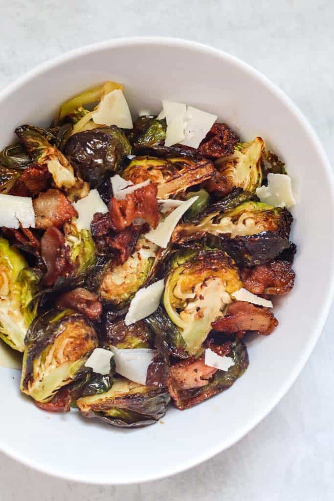 a bowl of brussels sprouts with bacon and parmesan