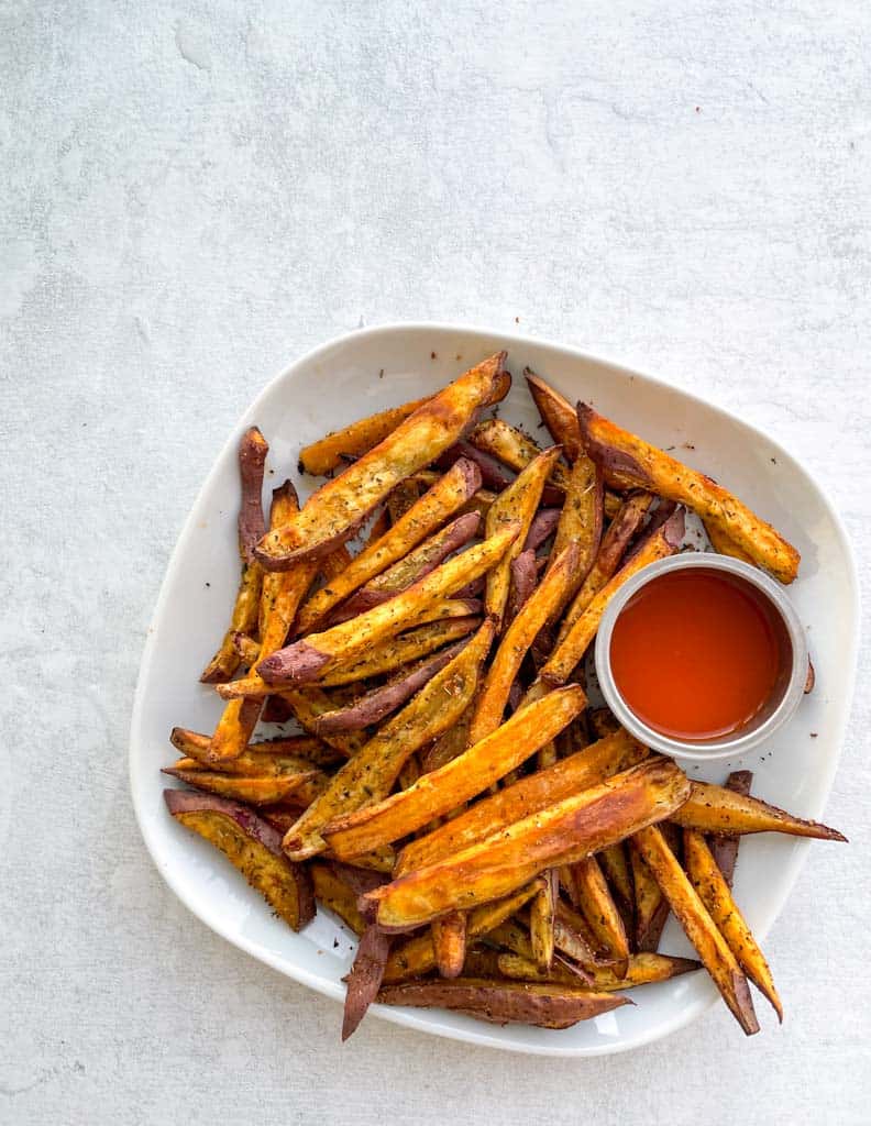 plate of sweet potato fries with ketchup on the side