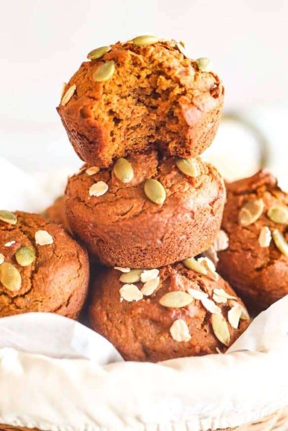 stacked pumpkin muffins with the top muffin bit into to reveal a soft, tender center