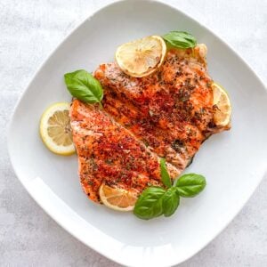 air fryer salmon on a white plate with garnish