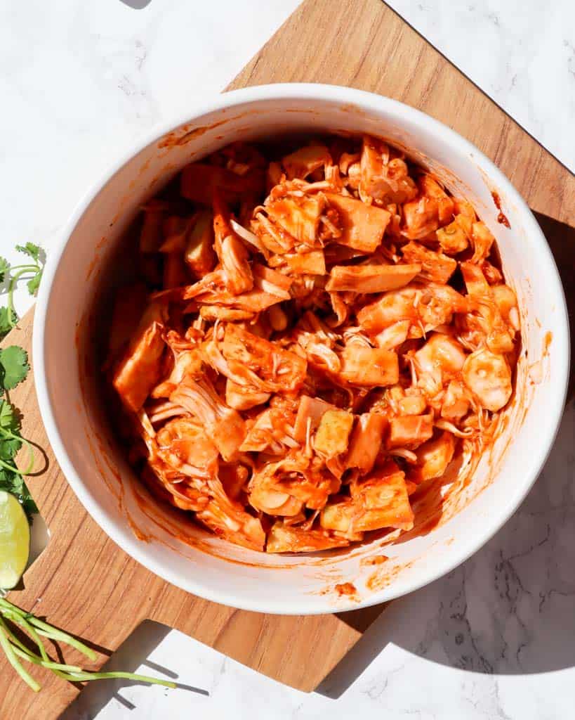 shredded jackfruit tossed in spices and barbecue sauce in a white bowl