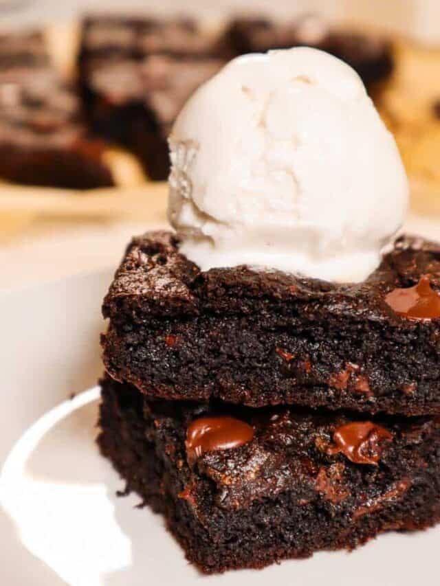 two gluten free vegan brownies stacked with a scoop of vanilla ice cream on top