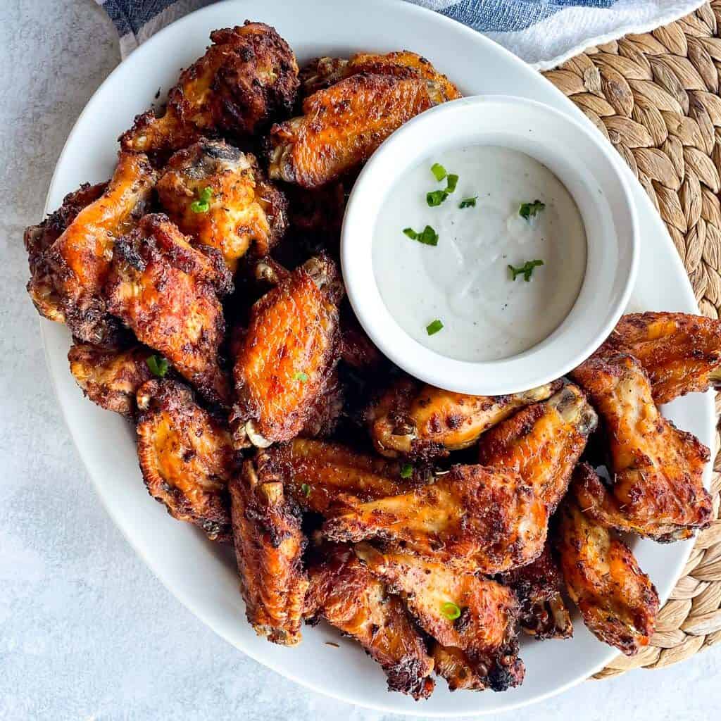 a platter of air fried chicken wings with a side of ranch