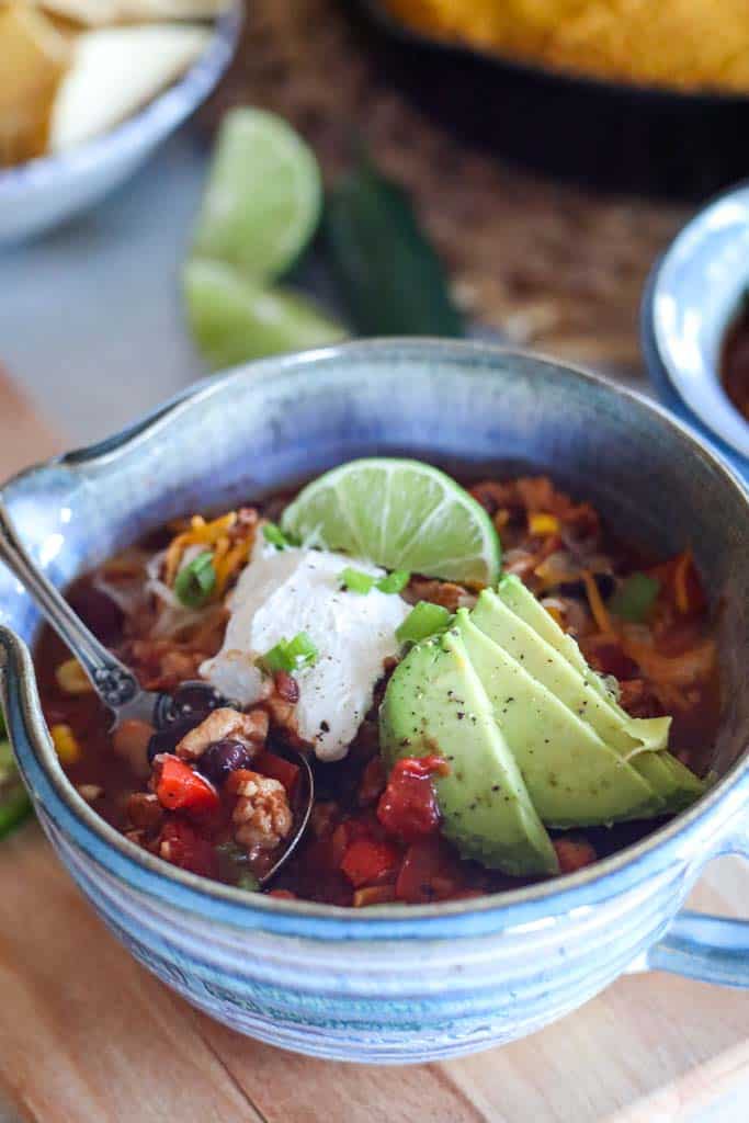 a bowl of turkey chili with assorted toppings