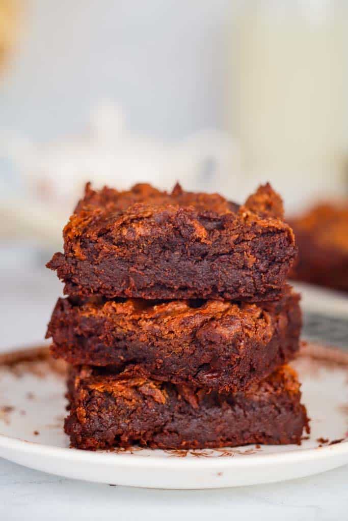 three stacked brownies on a white plate