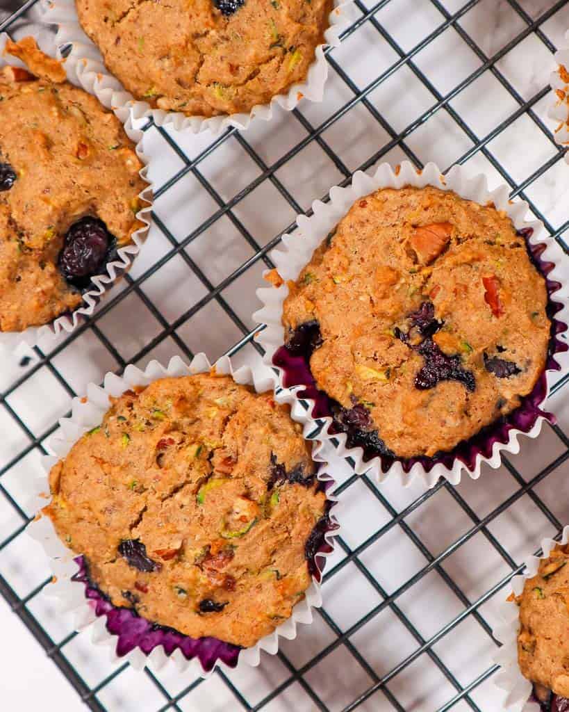 zucchini blueberry muffins on a wire rack