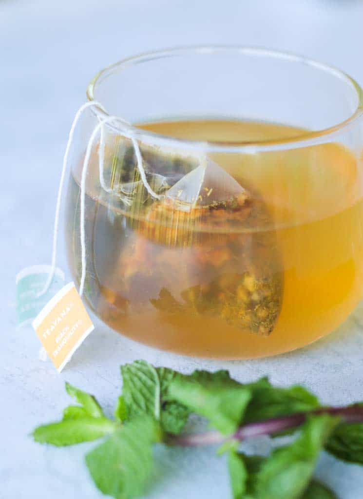 a cup of flu buster tea with two tea bags inside