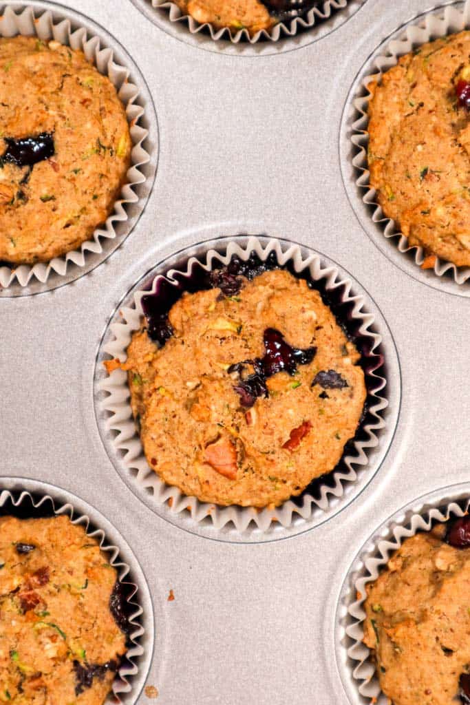 zucchini blueberry muffins in a muffin tin