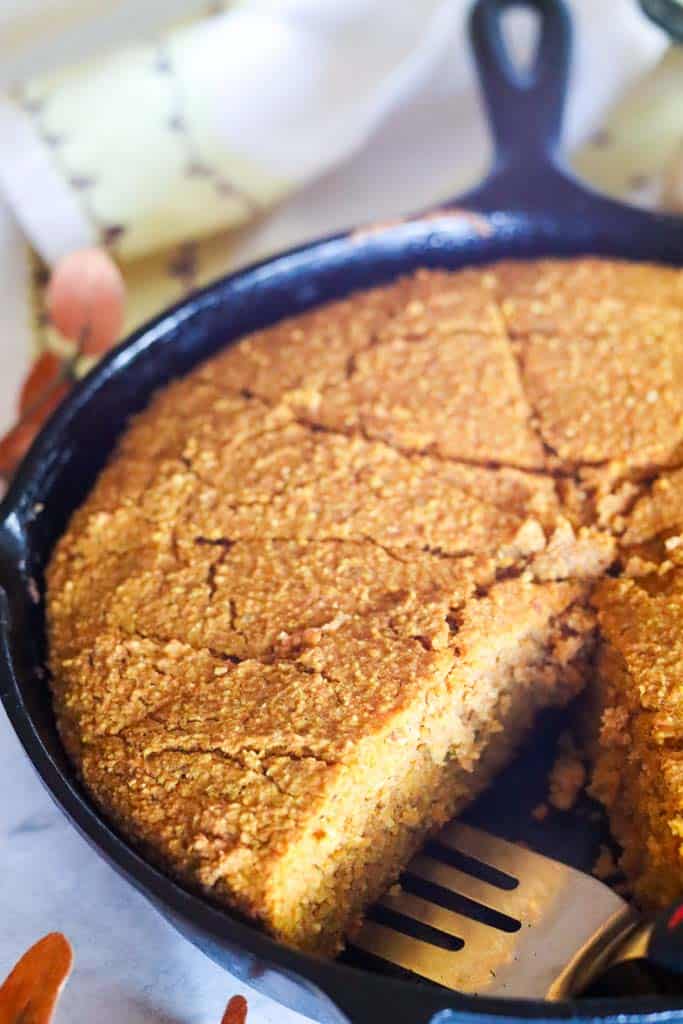 close up of sliced cornbread in a cast iron skillet