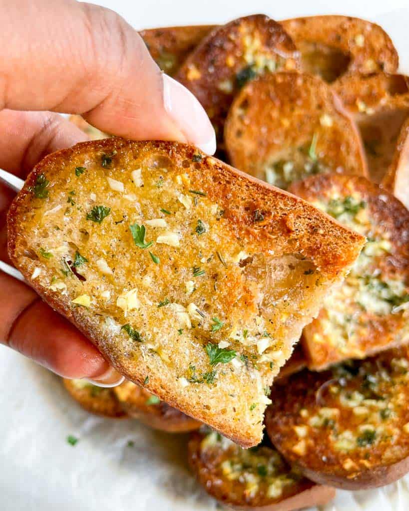 holding gluten free garlic bread close to show texture
