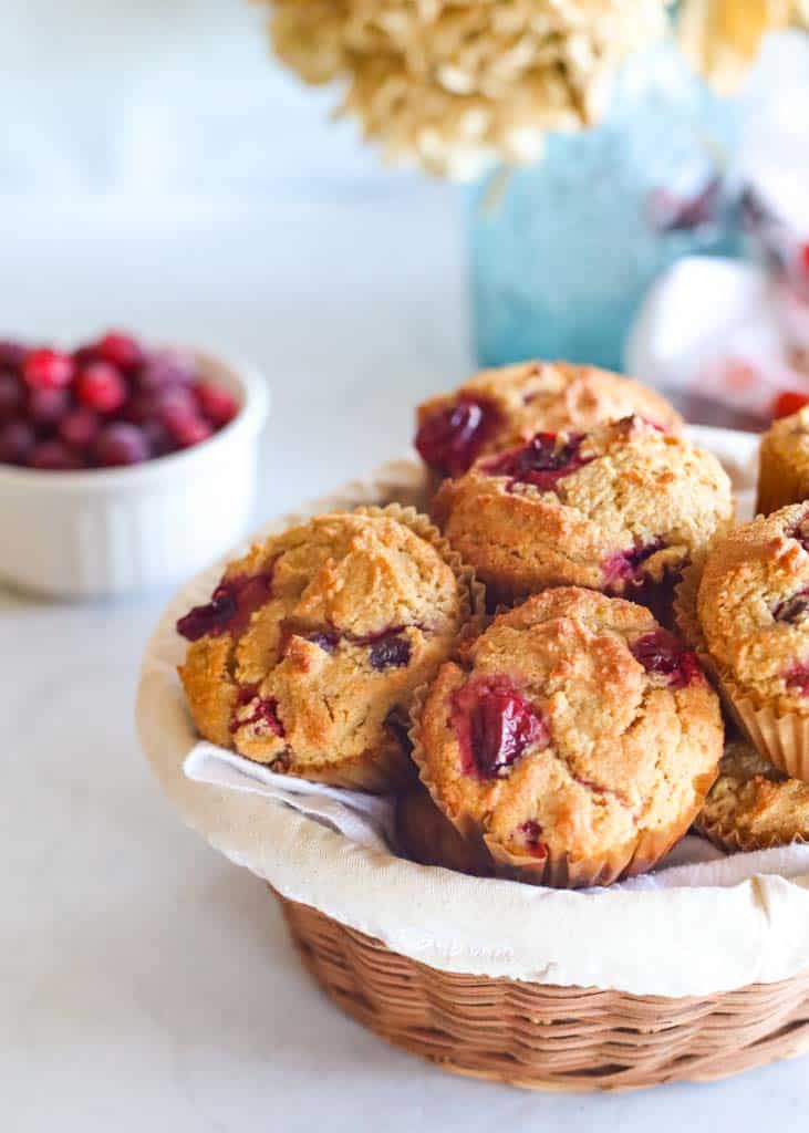 a basket full of cranberry muffins