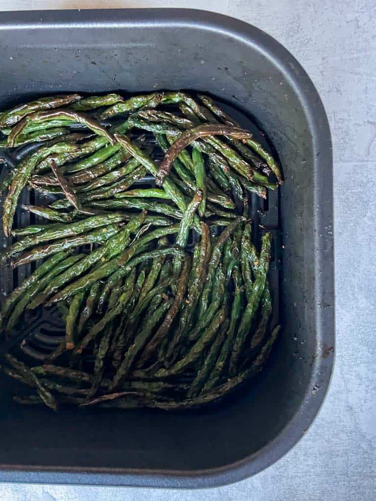 air fried green beans in an air fryer basket