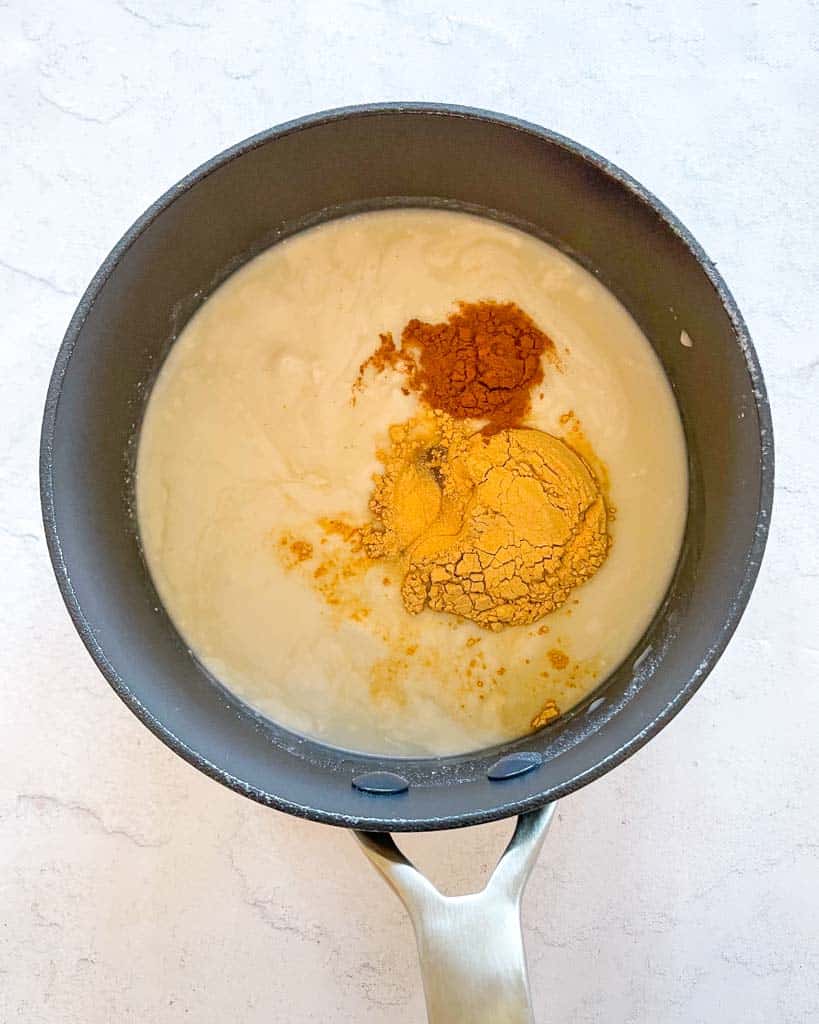 ingredients to make maca coffee shown inside a sauce pan before heating